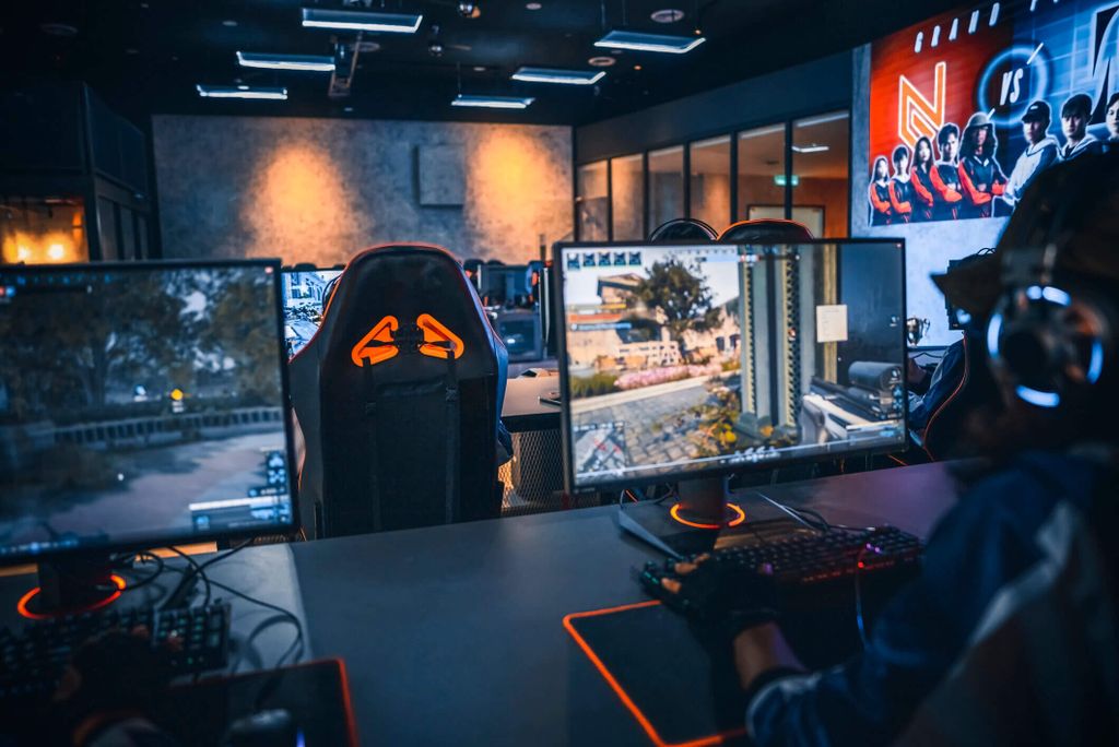 esports gamers are playing a game on computer screens