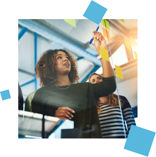 Young woman pasting sticky notes on a glass board