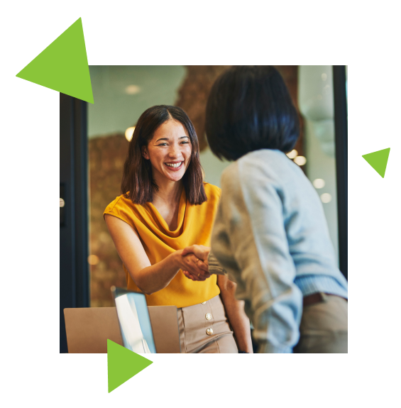 Two women shaking hands. Smile on the face of one woman and the back of the other woman's head.